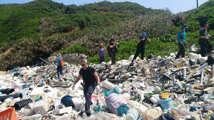 Ghost Net Hunter Harry Chan Tin-Ming 陳天明 with young people on a beach clean-up in Hong Kong surrounded by plastic and other waste